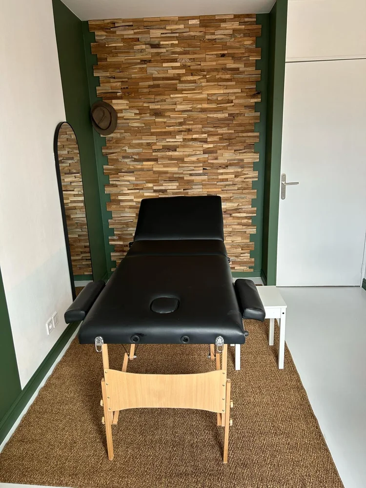 Table de soin O'Ki Soins devant un mur en bois, cabinet de digipuncture à Saint-Ouen-l'Aumône