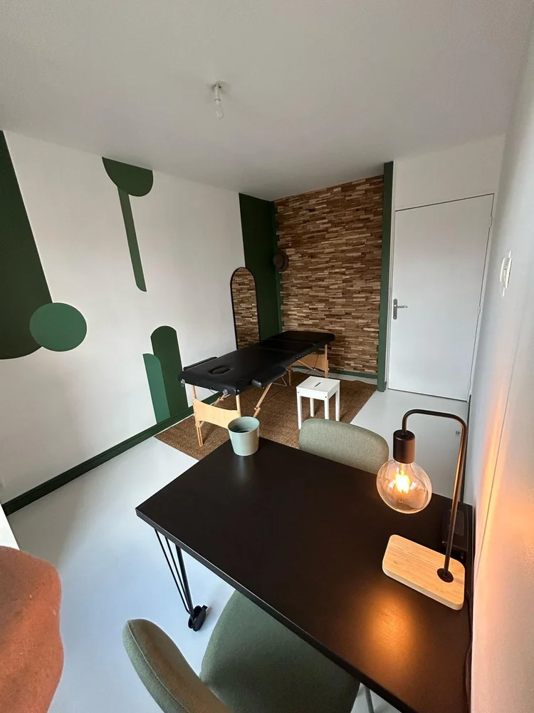 Espace de soin du cabinet O'Ki Soins avec bureau et décor vert apaisant